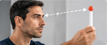 Man following a red-tipped pen held at arm’s length with his eyes